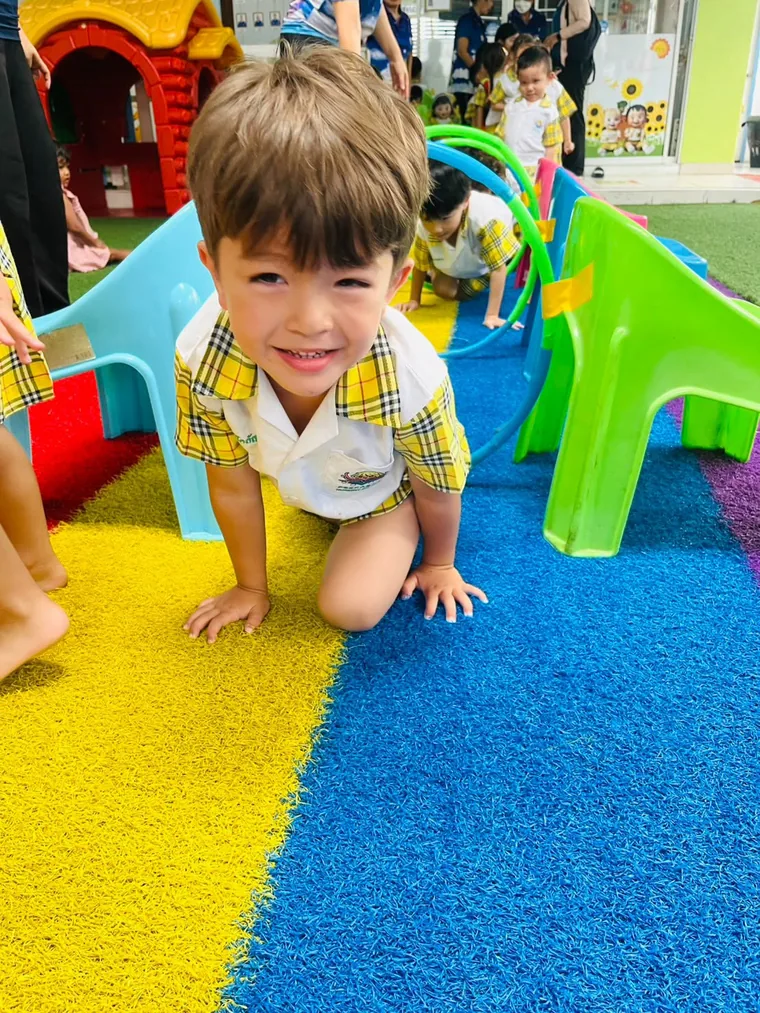 หนูน้อยยิ้มขณะคลานผ่านอุโมงค์ของเล่น